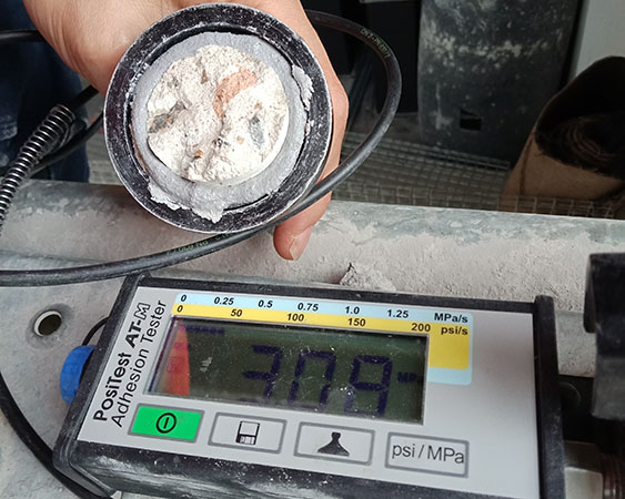 close up of a hand showing a piece of concrete after being tested